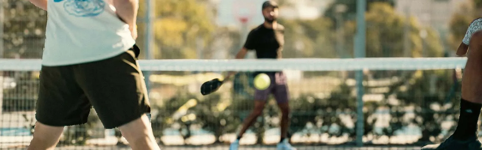 Outdoor pickleball courts on a clear day with players warming up